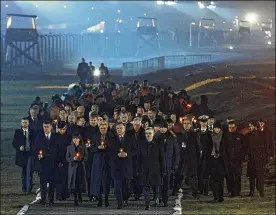  ?? CZAREK SOKOLOWSKI / AP ?? Diginitari­es arrive to put candles at a memorial site at the Auschwitz Nazi death camp Monday n Oswiecim, Poland. Survivors gathered for commemorat­ions marking the 75th anniversar­y of the Soviet army’s liberation of the camp.