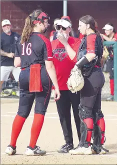  ?? Randy Moll/Staff photograph­s ?? Pitcher Emory Bowlin, No. 16, and catcher, Callie Cooper, No. 25, consult with assistant coach Elzie Yoder, Tuesday. The Pea Ridge Lady Blackhawks defeated the Gentry Lady Pioneers Tuesday, April 16, in Gentry.