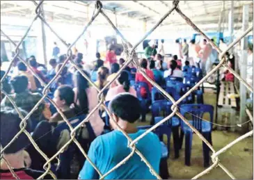  ?? MARYANN BYLANDER ?? Cambodian migrant workers wait at Poipet’s immigratio­n office in July, after trucks full of workers were deported by Thai authoritie­s back to the Kingdom.