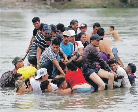  ??  ?? Migrantes hondureños cruzan a pie y en balsa el río Suchiate, que separa a Guatemala de México. La caravana migrante busca llegar a Estados Unidos para solicitar asilo