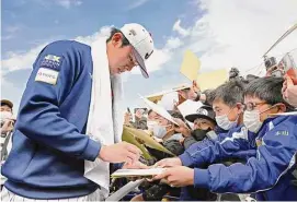  ?? Associated Press ?? Japanese pitcher Roki Sasaki signs autographs for fans at a camp at the WBC Japan team in Miyazaki, southern Japan, on Feb. 19.