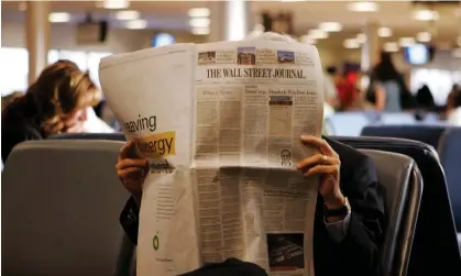  ?? ?? A commuter reads the Wall Street Journal while waiting for a flight in Atlanta, Georgia, in 2015. Photograph: Kiichiro Sato/AP