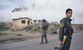  ??  ?? A YPG/PKK terrorist talks on his radio at a checkpoint near Omar oil field base, eastern Syria, Feb. 24, 2019.