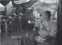  ?? Jerry Lara / Staff photograph­er ?? Eduardo Castro and his daughter, Brenda Mancilla, of El Salvador, eat breakfast in their tent at a migrant campsite last year in Matamoros, Mexico. The family is seeking asylum in the U.S.