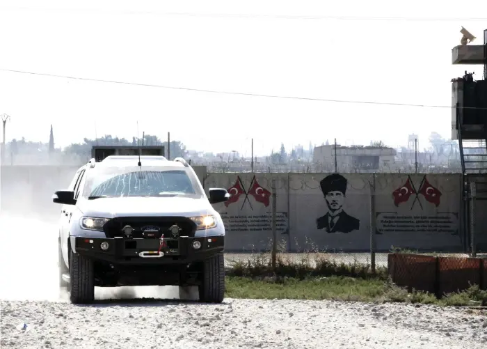  ?? Bild: Lefteris Pitarakis/tt/ap ?? Medlemmar i en turkstödd milis passerar gränsen mellan Syrien och Turkiet.