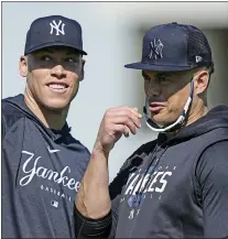  ?? DAVID J. PHILLIP — THE ASSOCIATED PRESS ?? Yankees’ Aaron Judge, left, and Giancarlo Stanton look to the stands before throwing out baseballs during a spring training baseball workout Monday in Tampa, Fla.