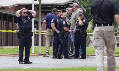  ?? ?? Police officers outside the Walnut Park elementary school in Gadsden, Alabama, after a fatal police shooting. Photograph: Jesse JarroldGra­pes/AP