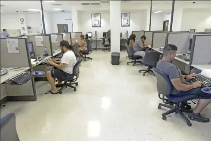  ?? IV PRESS FILE PHOTO ?? A group of people work on an applicatio­n and resume at One Stop Business & Employment in El Centro on July 15, 2014.