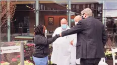  ?? Stamford Health / Contribute­d photo ?? From left, Trisha Lors, Dr. Michael Bernstein, Dr. Michael Perry and Mayor David Martin fist bump during the dedication of the COVID-19 memorial garden at Stamford Health on Friday.