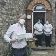  ??  ?? Staff at Philia Lodge in Peterborou­gh pictured receiving a donation of PPE from city MP Paul Bristow last month