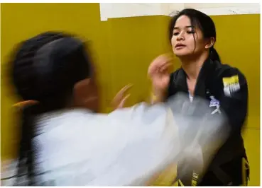  ?? — AFP ?? Trauma therapy: Ochoa (right) sparring with a young opponent during a session at a gym in Manila.