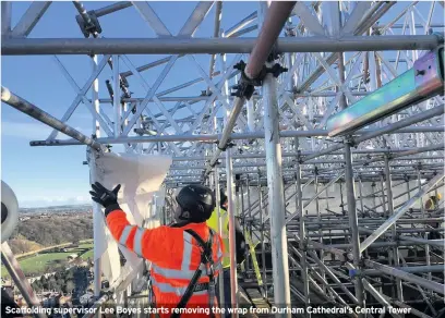  ??  ?? Scaffoldin­g supervisor Lee Boyes starts removing the wrap from Durham Cathedral’s Central Tower
