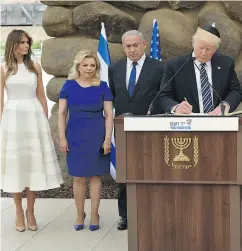  ?? GALI TIBBON, POOL VIA AP ORG ?? U. S. President Donald Trump signs the guest book at the Yad Vashem Holocaust Memorial museum, commemorat­ing the six million Jews killed by the Nazis during the Second World War.