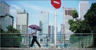  ?? REUTERS ?? A pedestrian walks near the headquarte­rs of China Evergrande Group (center) in Shenzhen, Guangdong province.