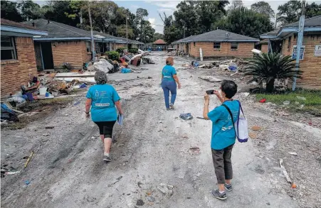  ?? Michael Ciaglo photos / Houston Chronicle ?? Catholic Charities USA members, from left, Helene Lauffer of New York City, Becky VanPool of Oklahoma City and Molly O’Donnell of Portland, Ore., look over a group of apartments that flooded as they canvas the Kashmere Gardens area.