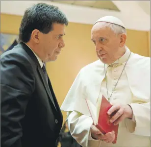  ?? AP PHOTO ?? In this file photo, Pope Francis presents Paraguay’s President Horacio Cartes with the book of the gospel during a private audience at the Vatican. Pope Francis is taking his “church for the poor” to three of South America’s poorest and most peripheral...