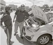  ?? Rick Bowmer / Associated Press ?? Salesman Doug Lund shows the engine of a Prius C hybrid to Mary Jean Jones in Salt Lake City. Auto sales have declined for five straight months.