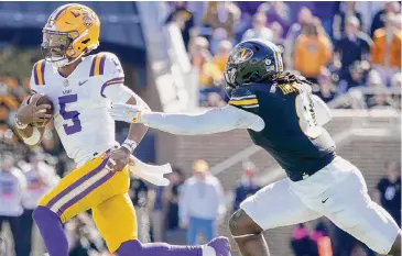  ?? Ed Zurga/Getty Images ?? LSU quarterbac­k Jayden Daniels rushes for a touchdown against linebacker Ty’Ron Hopper in the second half in Columbia, Mo. Daniels combined for 398 total yards and four touchdowns.