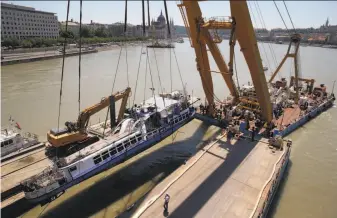  ?? Darko Bandic / Associated Press ?? A huge floating crane lifts the sightseein­g boat Hableany (Mermaid) out of the Danube River in Budapest, Hungary, where it sank after a collision with a river cruise ship late last month.