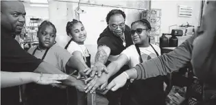  ?? Kin Man Hui / Staff photograph­er ?? Chef Milas Williams, center, and his volunteers put their hands together before departing to deliver Thanksgivi­ng meals, part of the sixth annual Youth Empowermen­t Thanksgivi­ng Dinner.