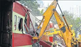  ?? PTI ?? A bulldozer takes down an illegally constructe­d eatery in the Kamala Mills compound in Mumbai on Saturday.