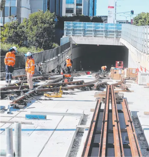  ??  ?? Workers laying tracks at the Gold Coast University Hospital station to link the light rail extension to the existing line.