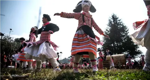  ??  ?? Girls dance at the annual flower festival in the village of Longjia in China’s Guizhou province. — AFP photo