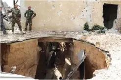  ??  ?? DAMASCUS: Syrian government forces inspect a destroyed tunnel in the capital’s northeaste­rn Al-Qaboun suburb yesterday. — AFP