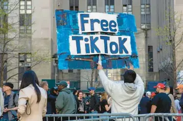  ?? TED SHAFFREY/AP ?? A man carries a “Free TikTok” sign outside the courthouse where Donald Trump’s hush money trial began April 15 in New York. President Joe Biden signed a bill to ban TikTok in the U.S. if its China-based owner doesn’t sell its stake.