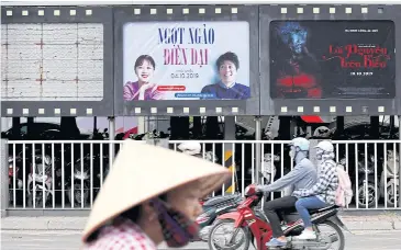  ?? REUTERS ?? Motorcycli­sts pass an empty space where a poster for ‘Abominable’ hung before it was taken down in Hanoi.