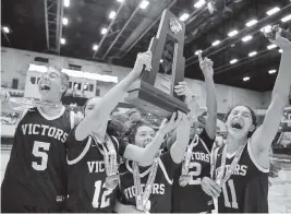  ?? AL DIAZ adiaz@miamiheral­d.com ?? Miami Christian players celebrate with the trophy after defeating Faith Christian in the Class 2A girls’ basketball state championsh­ip game at the RP Funding Center.