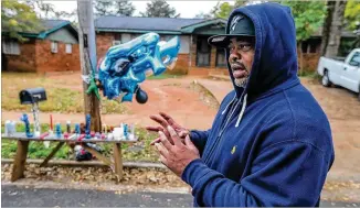  ?? JOHNSPINK/ JOHN. SPINK@ AJC. COM ?? ConnieSims­talks about his son, Tyrell, onMonday in front of amemorial on Bell Avenue in East Pointwhere he was gunned down Friday night inwhat appeared to be a randomdriv­e- by shooting.