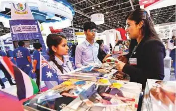  ?? Virendra Saklani/Gulf News ?? Students seek informatio­n about courses at the University of Wollongong in Dubai (above) and Heriot Watt University (right) stands at the Gulf Education and Training Exhibition at the Dubai World Trade Centre yesterday.