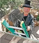 ?? MATT DAHLSEID THE NEW MEXICAN ?? Richard Rice, owner of Casey’s Top Hat Chimney Sweeps, climbs atop a roof with his gear Thursday in Santa Fe. His preferred wood for burning: oak. ‘Oak burns the longest and cleanest, and you get a lot of heat,’ he says.