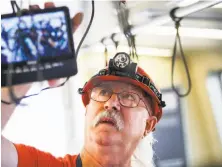  ?? Nicole Boliaux / The Chronicle ?? Jay Clemons, a BART transit vehicle electronic technician, installs new digital cameras at the Concord BART shop.