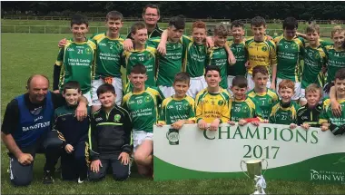  ??  ?? The St Nicholas footballer­s and mentors celebrate with the cup after their magnificen­t Féile na nGael success from