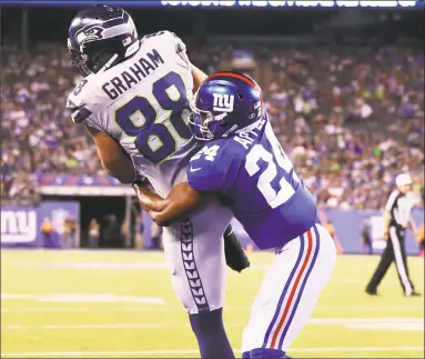  ?? Al Bello / Getty Images ?? Jimmy Graham of the Seahawks scores a touchdown against Eli Apple of the Giants during the fourth quarter of Sunday’s game at MetLife Stadium in East Rutherford, N.J.