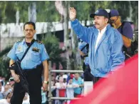  ?? EFE ?? Marcha. Escoltado por uno de sus guardas de seguridad armados, el presidente Daniel Ortega, derecha, saluda a una multitud de seguidores de su partido durante una marcha antier.