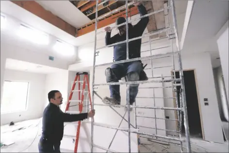  ?? LM OTERO/AP ?? Joshua Correa (left) steadies a scaffoldin­g for Samuel as they work at a home under constructi­on in Plano, Texas on Tuesday.