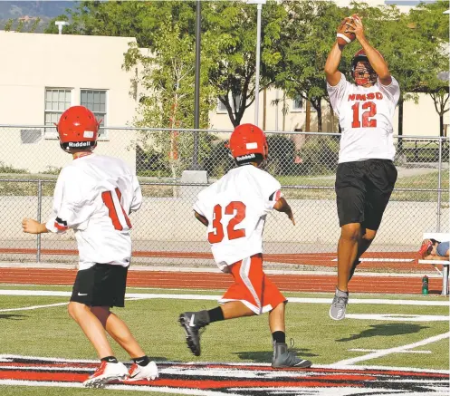  ?? PHOTOS BY JANE PHILLIPS/FOR THE NEW MEXICAN ?? Deven Thompson snares a pass Thursday during practice at the New Mexico School for the Deaf. The six-man football team looks to improve on last year’s 3-3 record, and the 6-foot-10, 240 pound senior will be a big part of the program.