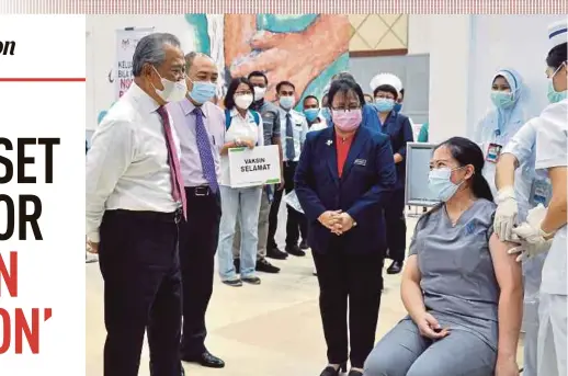  ?? PIC BY MOHD ADAM ARININ ?? Prime Minister Tan Sri Muhyiddin Yassin chatting with dental assistant Debby Marjezlina (second from right) as she gets the Covid-19 vaccine at the Sabah Federal Administra­tive Complex vaccinatio­n centre in Kota Kinabalu yesterday. With him are Sabah Chief Minister Datuk Seri Hajiji Noor (second from left) and Sabah Health director Datuk Dr Christina Rundi (centre).