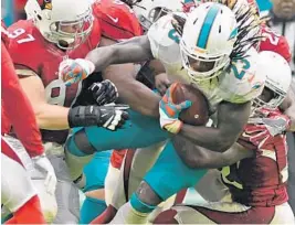  ??  ?? Dolphins running back Jay Ajayi gains a few tough yards against the Cardinals.