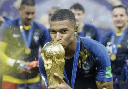  ?? MATTHIAS SCHRADER — THE ASSOCIATED PRESS ?? France’s Kylian Mbappe kisses the trophy after the final match between France and Croatia at the 2018 soccer World Cup in the Luzhniki Stadium in Moscow, Russia, Sunday. France won the final 4-2.