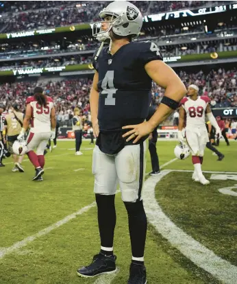  ?? JOHN LOCHER/AP ?? Raiders QB Derek Carr stands on the field after an overtime loss to the Cardinals on Sept. 18 in Las Vegas.