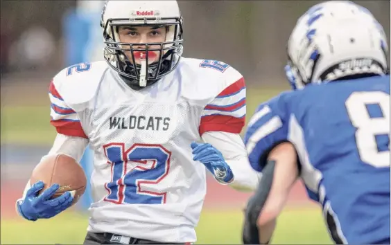  ?? James Franco / Special to the Times Union ?? Hoosick Falls/tamarac quarterbac­k Michael Dagostino looks for running room in front of Coxsackie-athens senior Brandon Wolbert during a game at Coxsackie-athens High School on Friday. Dagostino threw three touchdown passes as the Wildcats parlayed a big second half into a win.