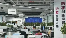  ?? ZHANG CHENLIN / XINHUA ?? Employees work at a financial tech company in Beijing.