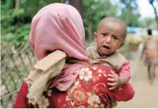  ?? — Reuters ?? Rohingya refugees, who crossed the border from Myanmar two days earlier, walk to the Kutupalong refugee camp, in Balukhali on Thursday.