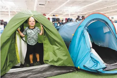  ?? Photos by Michael Short / Special to The Chronicle ?? Above: Jonah Pletka peeks out of a tent while shopping with his mom and sister at the Emeryville Decathlon, an affordable sporting goods outlet.