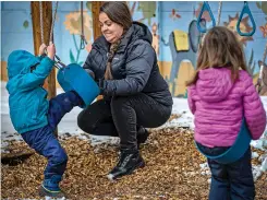  ?? JIM WEBER/NEW MEXICAN FILE PHOTO ?? Anya Eckert, center, lead teacher at La Casita Preschool in northern Santa Fe, helps extricate 3-year-old Gus Dicks from a swing in February 2022 while he plays outside at the preschool. A national report shows increased access to state-funded prekinderg­arten programs and growing enrollment.