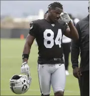  ?? JEFF CHIU —ASSOCIATED PRESS ?? Antonio Brown, left, walks off the Raiders’ practice field in Alameda on Tuesday with his new, and approved, helmet.